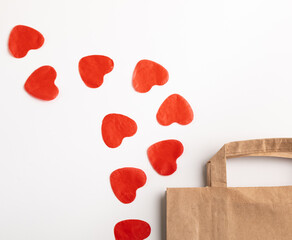 The concept of shopping as a holiday, paper bag and a fairwork of paper hearts on a white background.