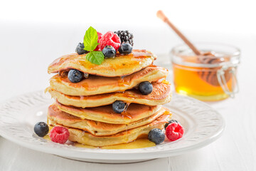 American pancakes served with berries and honey. Pancakes for breakfast.