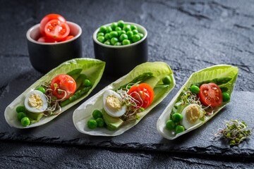 Tasty salad in chicory with avocado, asparagus and peas.