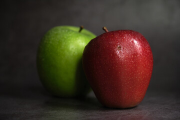 green and red apple on dark background