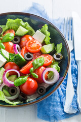 Greek salad made of cherry tomatoes, onion and lettuce.