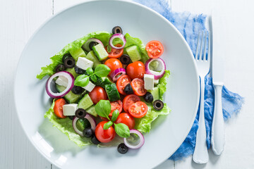 Fresh Greek salad in white plate. Healthy green salad.