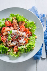 Caesar salad made of chicken, cherry tomatoes and parmesan