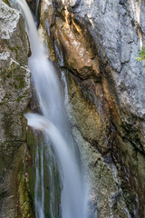 Fototapeta na wymiar Wasser strömt den Fels hinab