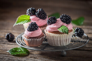 Delicious and homemade blackberry cupcake with cream and fruits.