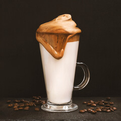 Glass cup fluffy coffee with milk and coffee beans on a black background. Coffee drink latte сreamy caramel dripping foam
