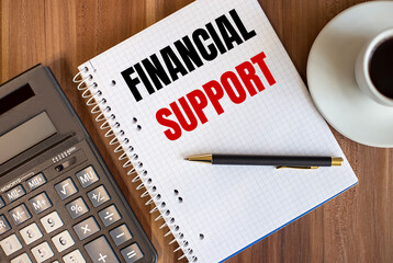 FINANCIAL SUPPORT written in a white notepad near a calculator and a cup of coffee on a dark wooden background