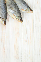 dry fish on a white wooden table, view from above