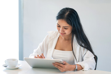 Business woman Asian holding a tablet working at the office.