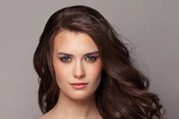 Pretty woman face with curly brown hair portrait