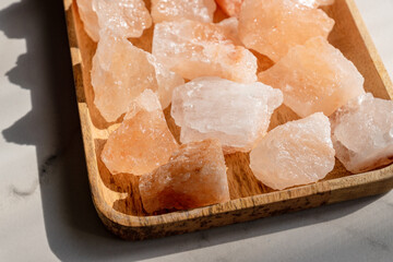 Crystals of Pink himalayan salt on wooden tray, interior deoration, spa and heath care concept