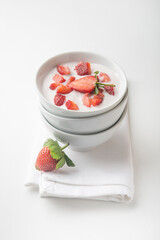 Very healthy and refrehing youghurt smoothie with fresh strawberry served in a white bowl. Food photography and recipes of healthy and nutritious food.