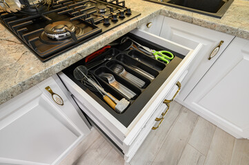 Drawers pulled out at modern classic white kitchen furniture