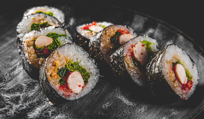 Teriyaki chicken sushi roll in plate on black background