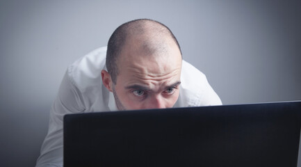 Caucasian man working with laptop.