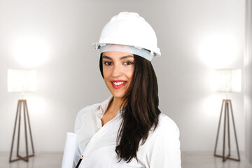 A smiling female architect with protective helmet inside a modern living room with two lamps. Subject on a blurred background.