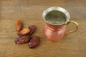 Ramadan iftar food, delicious date fruits  and drinking water in a copper mug. 