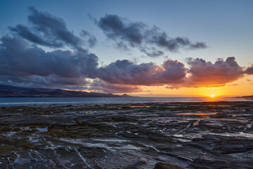 Obraz premium Beautiful sunset in a volcanic bay