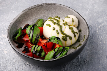 buratta. salad with buratta, pesto, basil, tomatoes and balsamic. caprese salad with buratta