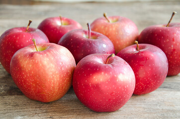 A bunch of red apples on a vintage, wooden background. Rustic style. The fruit is on the table. A healthy and vitamin snack.