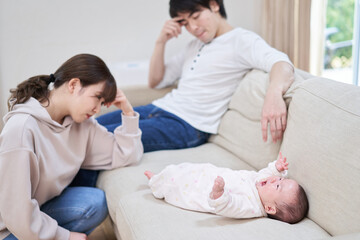 泣き止まない赤ちゃんに疲れるアジア人の両親