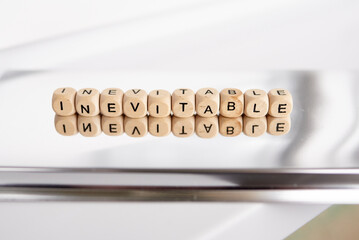 Word inevitable by wooden cubes