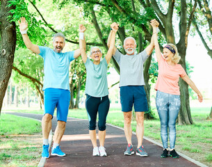 Obraz premium outdoor senior fitness woman man lifestyle active sport exercise healthy fit retirement teamwork together holding hands