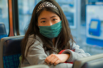 urban lifestyle during covid19 - young pretty and sweet Asian Chinese woman with mask and backpack...