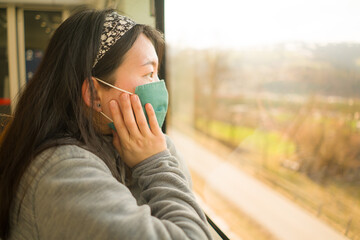 train travel in times of covid19 - young happy and cute Asian Korean woman in  face mask traveling...
