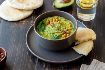 Avocado hummus in a gray bowl. Healthy eating. Vegetarian food.