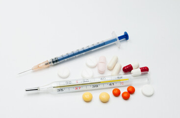 medical mercury thermometer with tablets on a white background