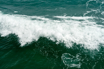Aquamarine sea wave with white foam