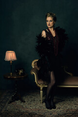 Seductive young woman with a black boa in retro boudoir attire w