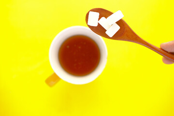 cup of tea and sugar cube on spoon