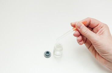 hand with medical pipette on white background