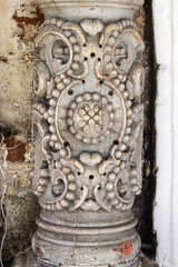 Fragment of an old column with a decorative pattern at the entrance to the church.