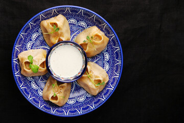 Stuffed dumplings, manti of dough and minced, close up Traditional chinese dim sum dumplings on dark background