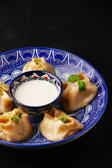 Stuffed dumplings, manti of dough and minced, close up Traditional chinese dim sum dumplings on dark background