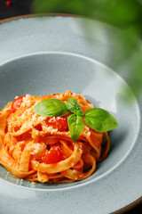 Spaghetti with tomato sauce and basil leaf closeup