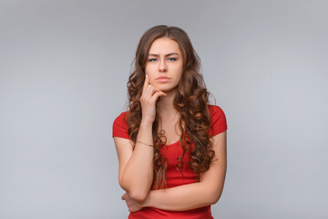 Hmm, interesting. Thoughtful young brunette woman, looking at camera and thinking about something,...