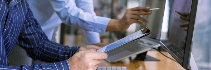 broker showing some ascending to his colleague planning and analyzing graph stock market trading with stock chart data on multiple computer screens.