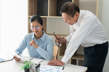 Senior and young businessman colleagues discuss online project to learning new skills or Coaching Business Team with young intern looking at pc screen in the office.
