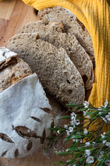 Bread slices close up photo. Rye sourdough bread on a table, yellow fabric background.  Wholegrain loaf texture. 