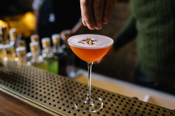 Bartender preparing whiskey sour cocktail and decorating it. 