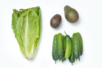 Top view, vegan set made of salad green Romaine Lettuce, cucumbers and avocados on the white background. Food concept. Copy space.
