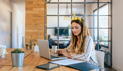 Business woman with unicorn headband working in the office