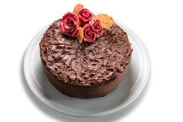 Chocolate cake with sugar red roses in white plate, top view