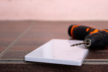 Close-up of drill bit plugged into the orange cordless drill.