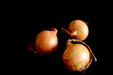 fresh raw yellow onions on black background