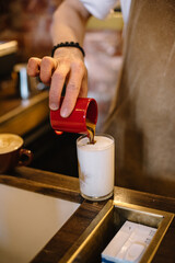 Pouring coffee into a cup of milk. Latte coffee.
